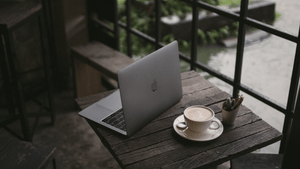 A laptop on a coffee table with a lovely coffee