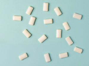 A blue background with piece of chewing gum scattered on it