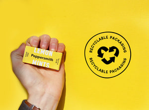 A yellow background with a hand holding Leon Mints and a black stamp saying 'RECYCLABLE PACKAGING'