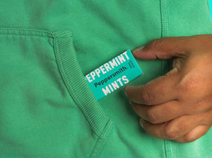 Peppersmith Peppermint Mints being slipped into a green hoodie 